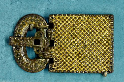 A rectangular Visigothic belt buckle with a metal frame and a large decorated plate inlaid with coloured stones and glass.